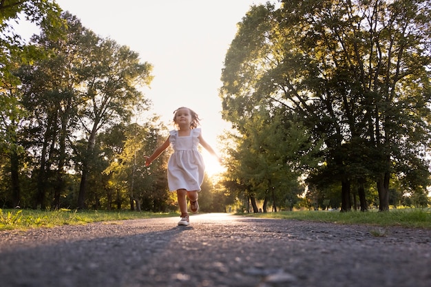 Full shot little girl running outdoors