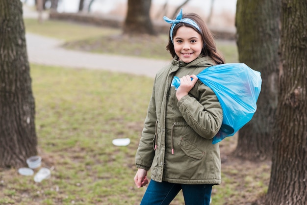 Full shot of little girl with plastic bag