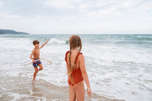 Full shot little kids having fun at the beach