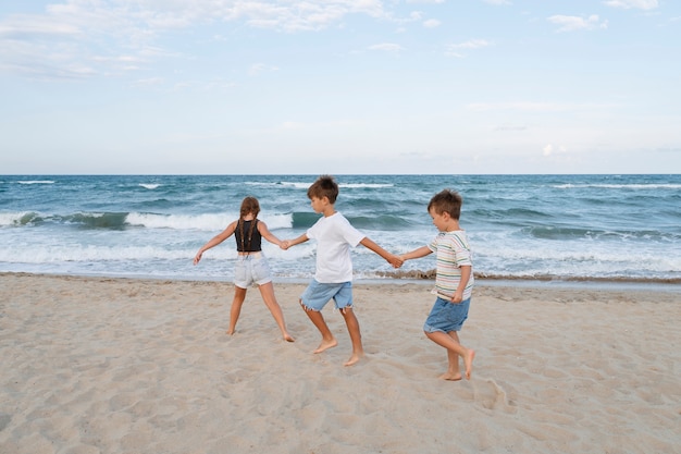 Full shot little kids having fun at the beach