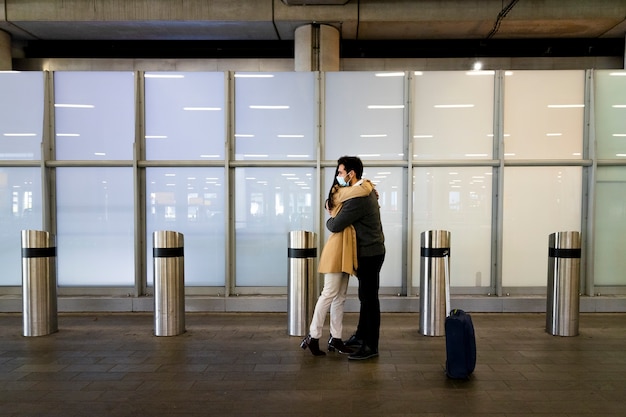 Full shot long-distance couple meeting at airport