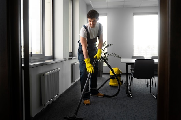 Full shot man cleaning indoors