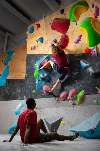 Full shot man climbing wall