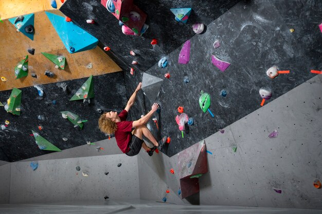 Full shot man climbing wall