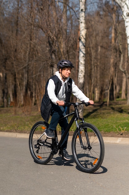 Free photo full shot man cycling outdoors