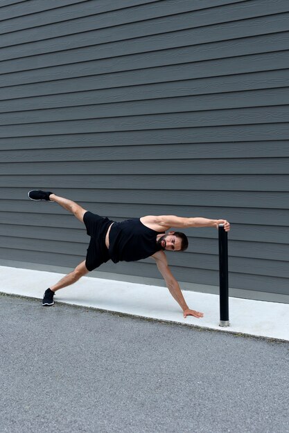 Full shot man doing side plank