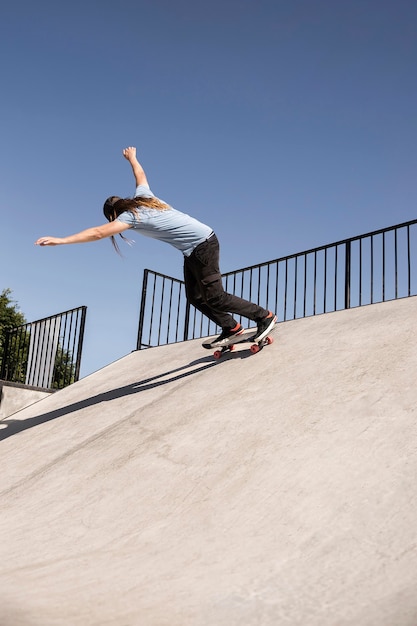 Full shot man doing tricks in skatepark