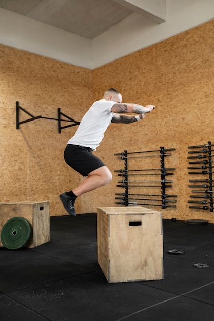 Full shot man exercising with box