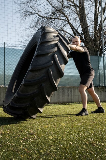 Full shot man exercising with wheel