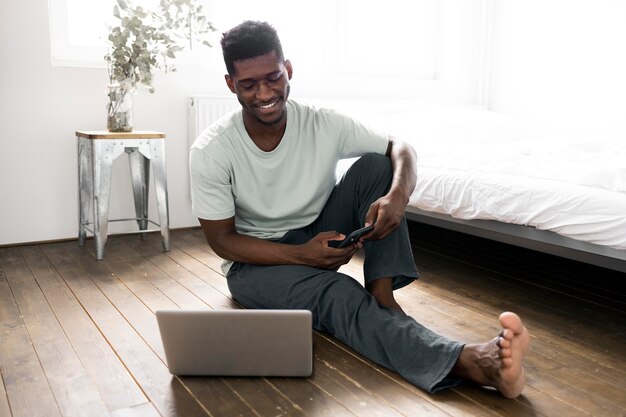 Full shot man on floor with laptop