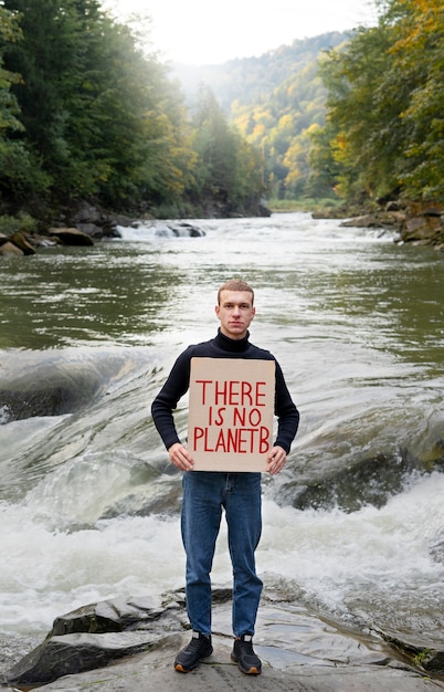 Free photo full shot man holding banner with message