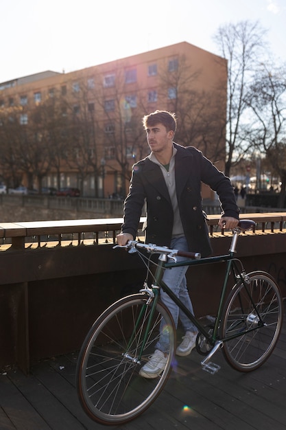 Free photo full shot man holding bicycle