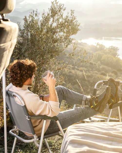 Free photo full shot man holding cup outdoors