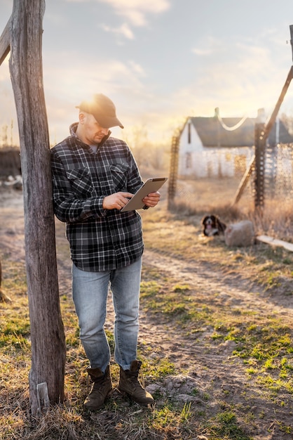 Free photo full shot man holding tablet outdoors