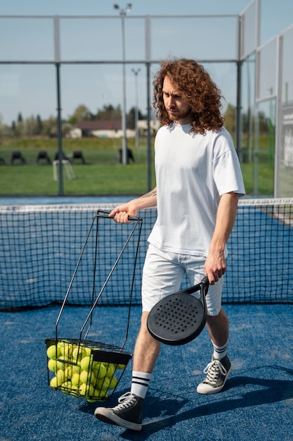 Full shot man holding tennis paddle