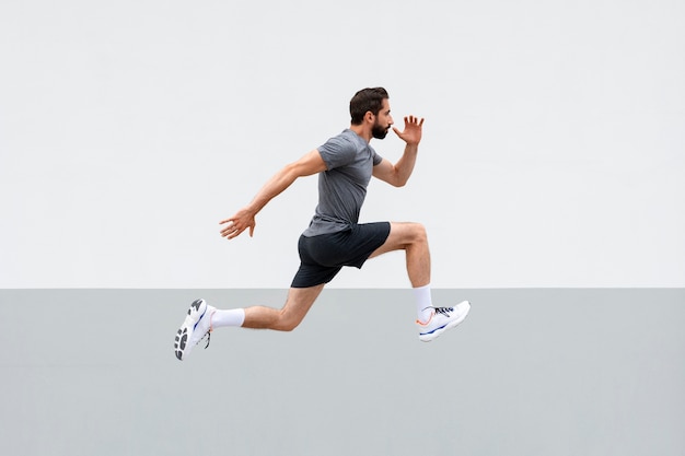 Full shot man jumping outdoors