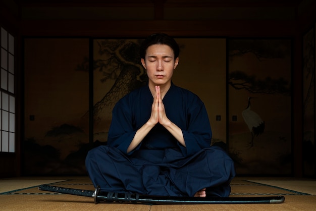 Full shot man meditating indoors