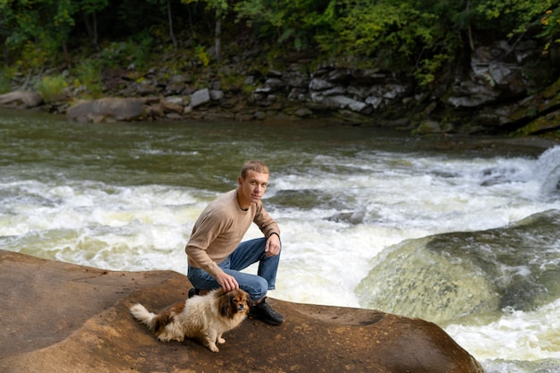 Free photo full shot man petting dog