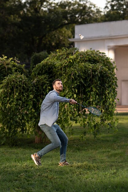 Full shot man playing badminton