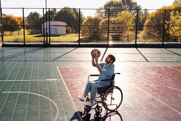 Full shot man playing basketball outdoors