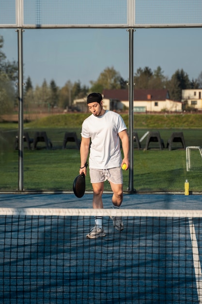 Full shot man playing paddle tennis