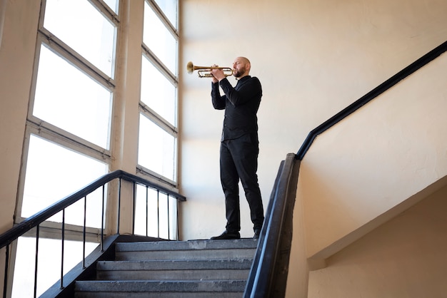 Full shot man playing the trumpet