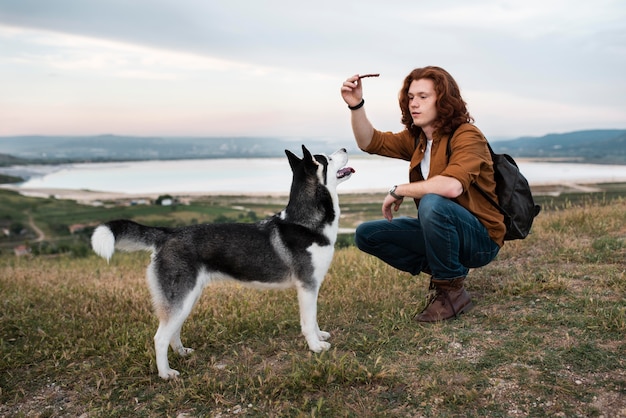 Full shot man playing with dog