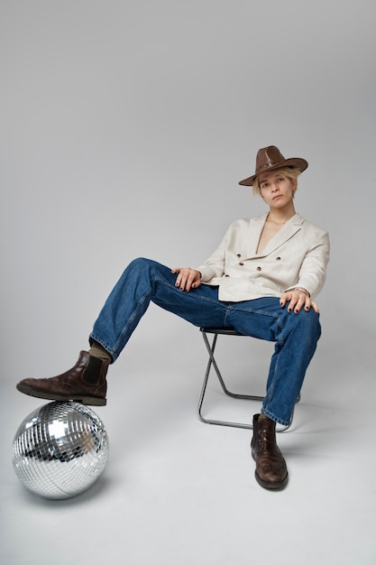 Full shot man posing with disco ball