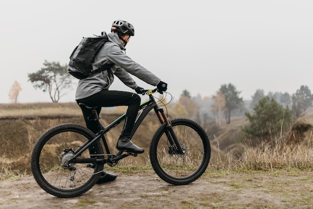 Free photo full shot of man riding a bike