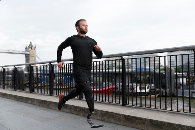 Full shot man running with prosthesis