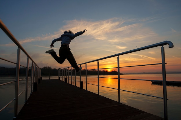 Free Photo full shot man silhouette jumping at sunset