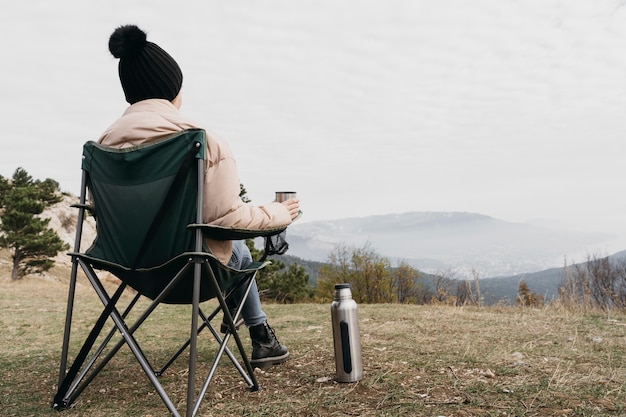 Free photo full shot man sitting on chair outdoors