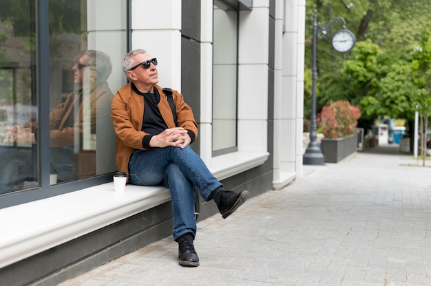 Full shot man sitting outdoors