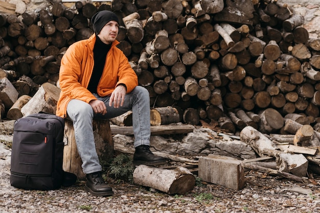 Free photo full shot man sitting on stump