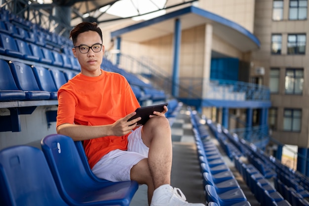 Full shot man sitting with tablet