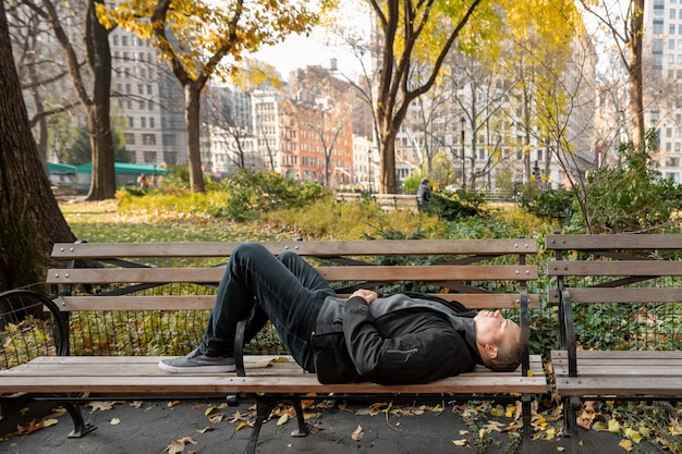 Full shot man sleeping on bench