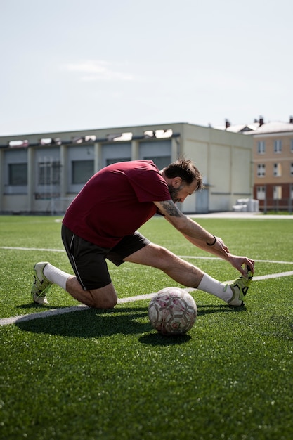 Free photo full shot man stretching on field