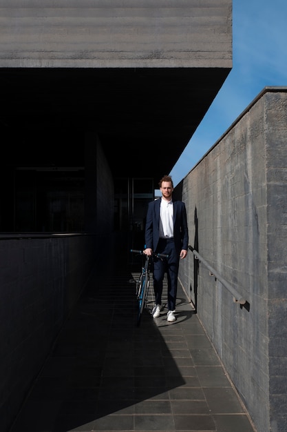 Free Photo full shot man in suit with bicycle going to job