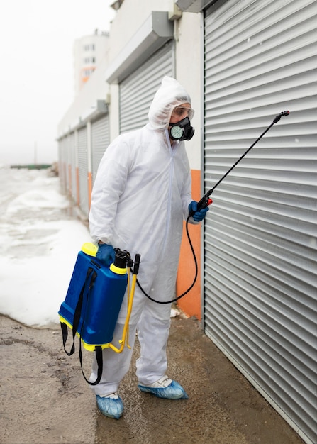 Free photo full shot man in suit with disinfectant