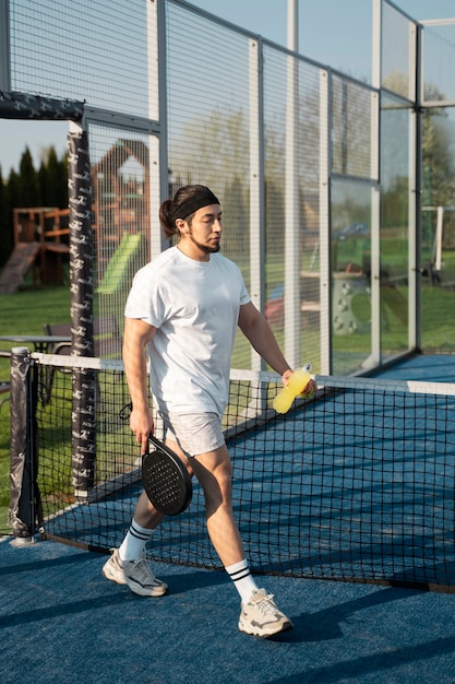 Full shot man in tennis court