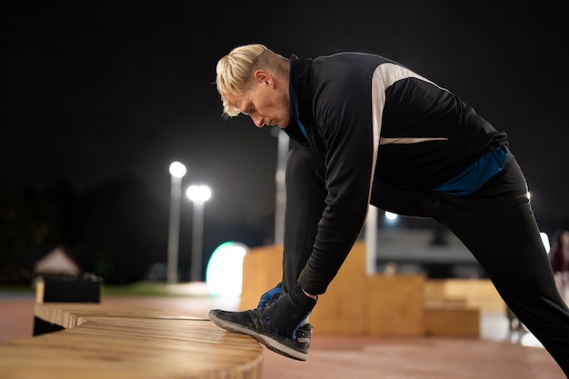 Free photo full shot man tying shoelaces