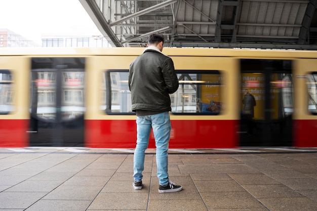 Free photo full shot man waiting for train