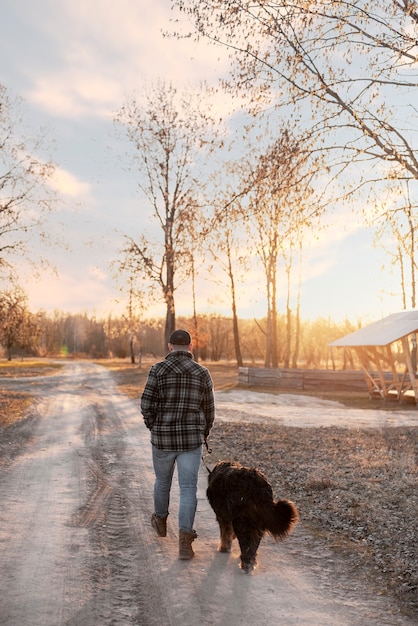 Free Photo full shot man walking with dog outdoors