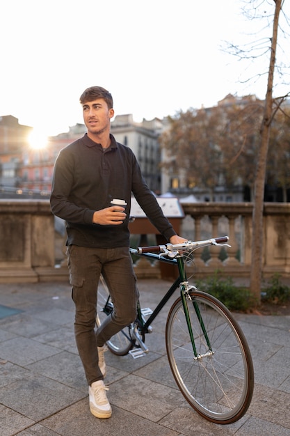 Full shot man with coffee and bicycle