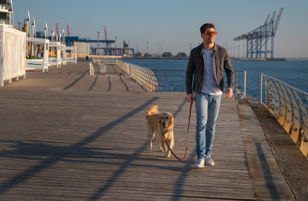 Free photo full shot man with dog on a jetty