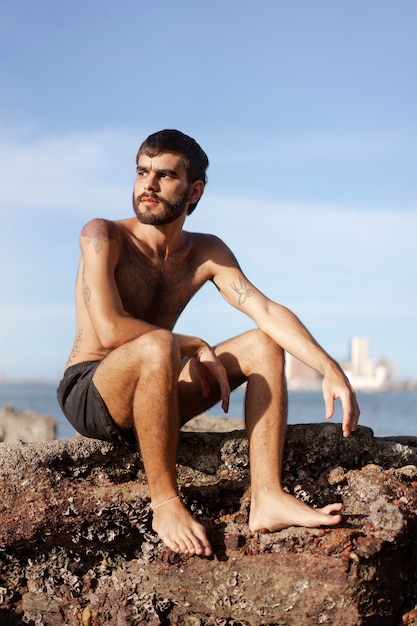 Full shot man with hairy chest at seaside