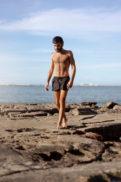 Full shot man with hairy chest at seaside