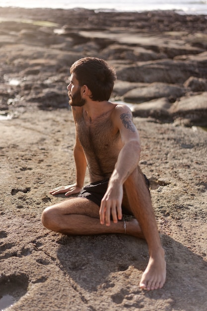 Full shot man with hairy chest at seaside