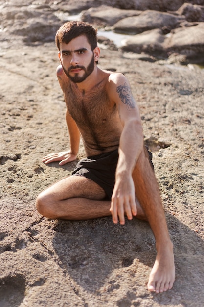 Full shot man with hairy chest at seaside