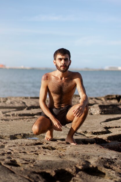 Full shot man with hairy chest at seaside